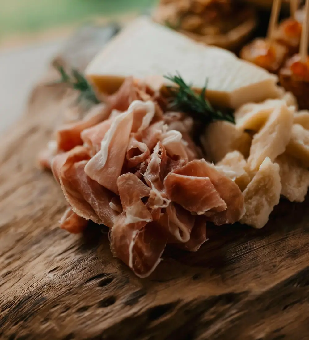 An assortment of Mediterranean small plates with olives, bread and dips on a warm wooden table