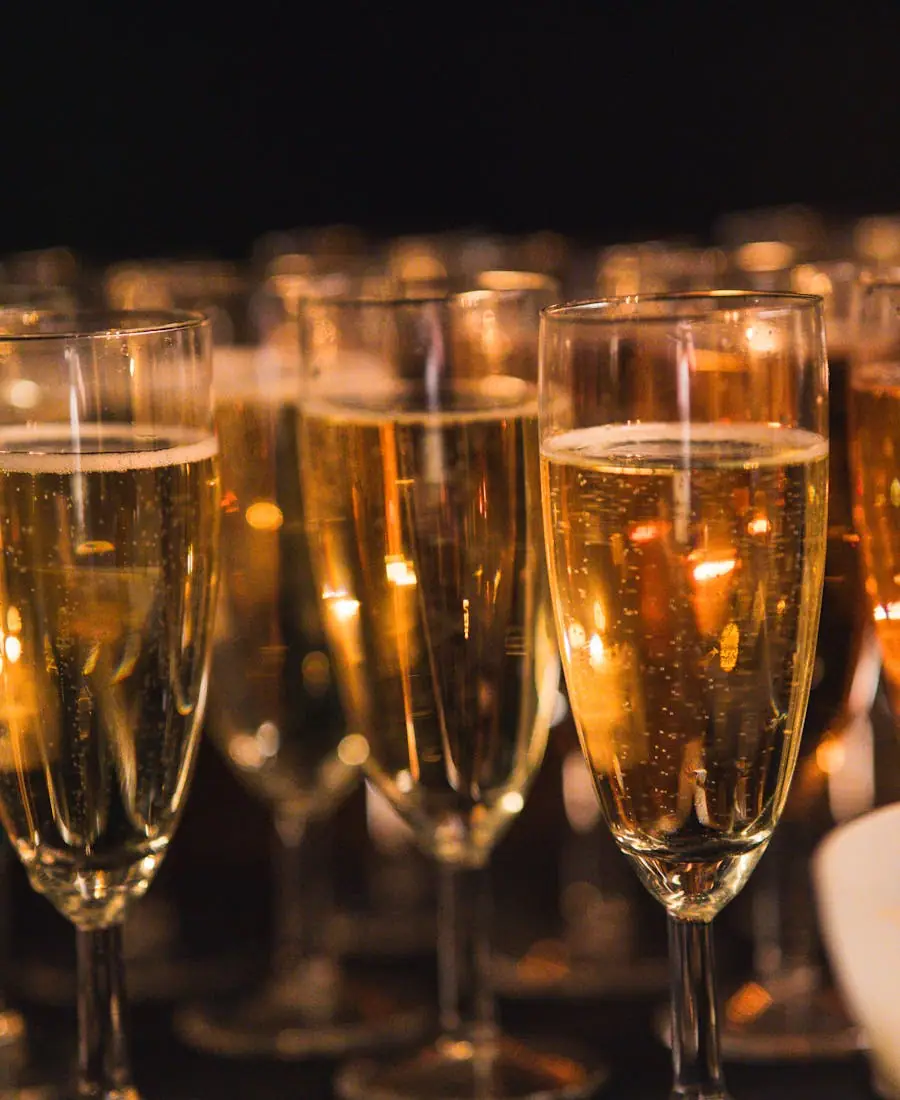 A flute of sparkling wine with rising bubbles glowing against soft light